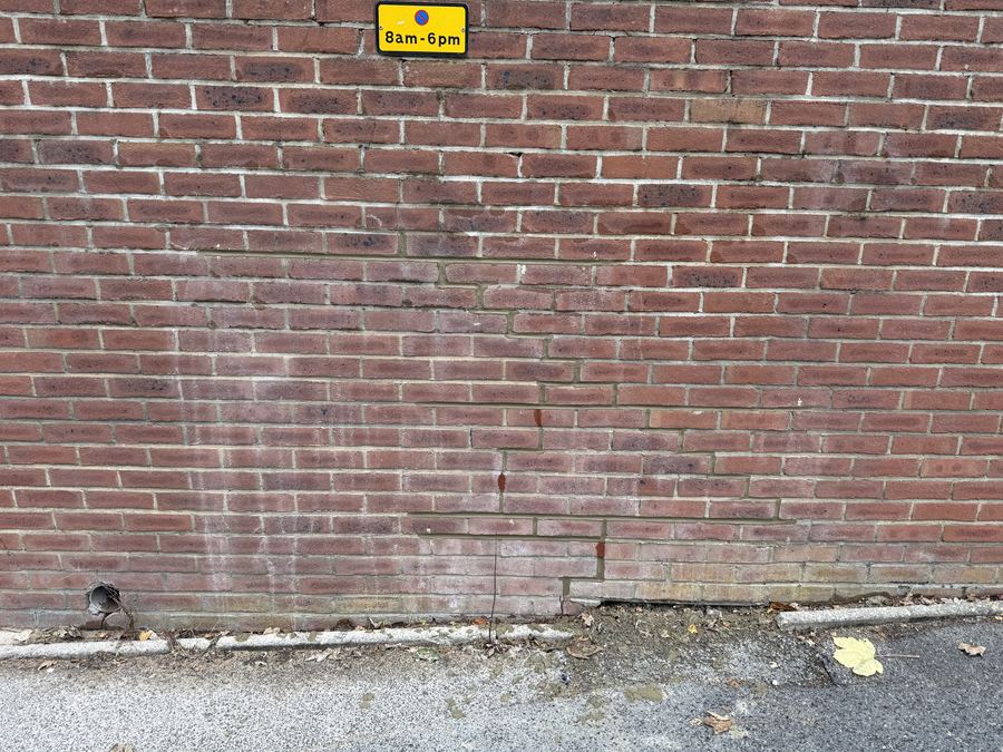Crack stitching repair to a retaining wall