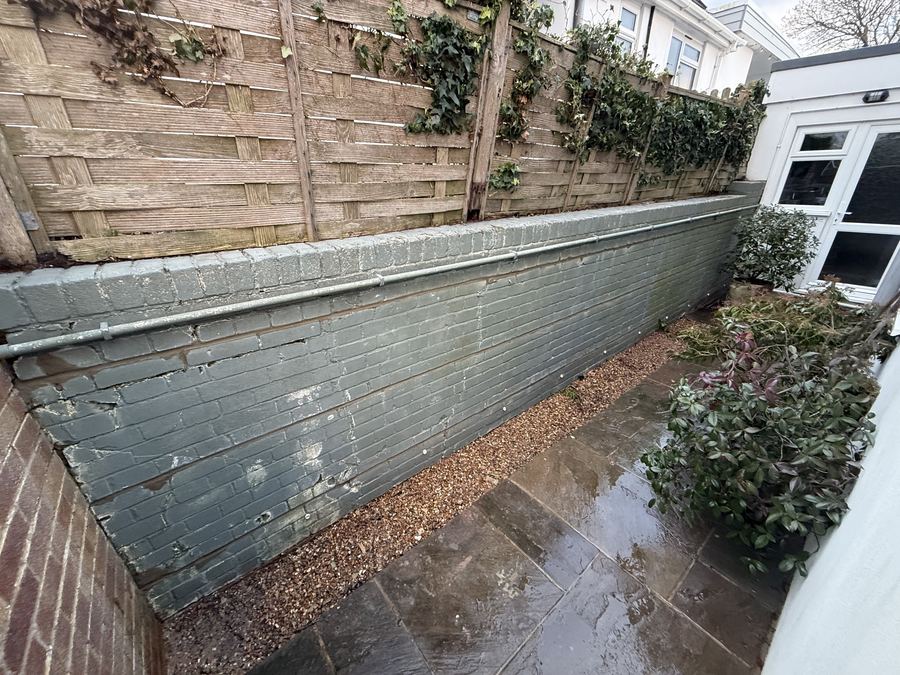 Crack stitching repair to a bulging retaining wall